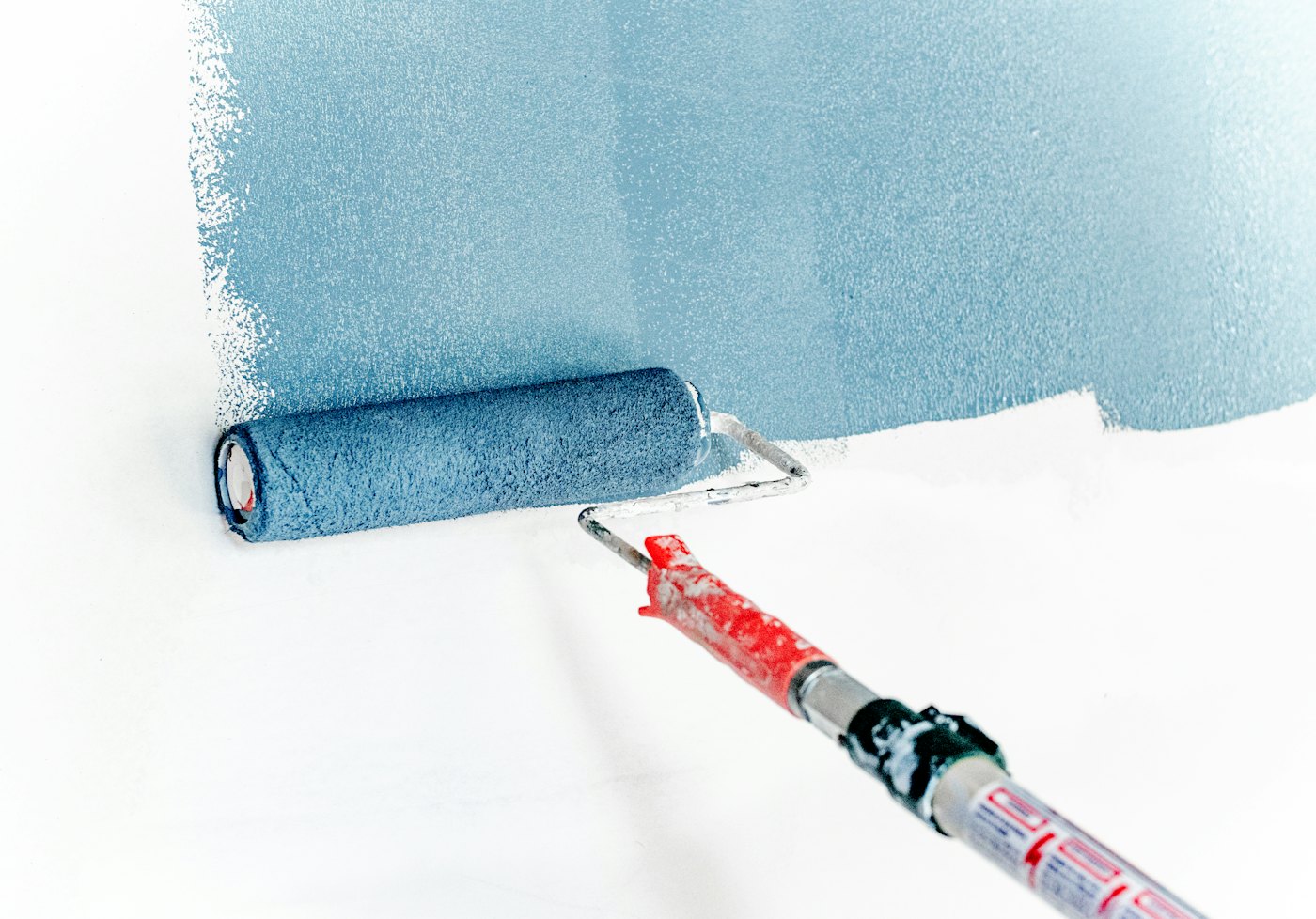 Paint roller laying a fresh coat of colour on a wall