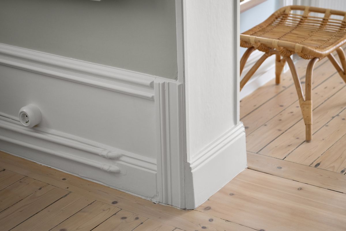 Crisp white skirting boards and wall moulding above a wooden floor